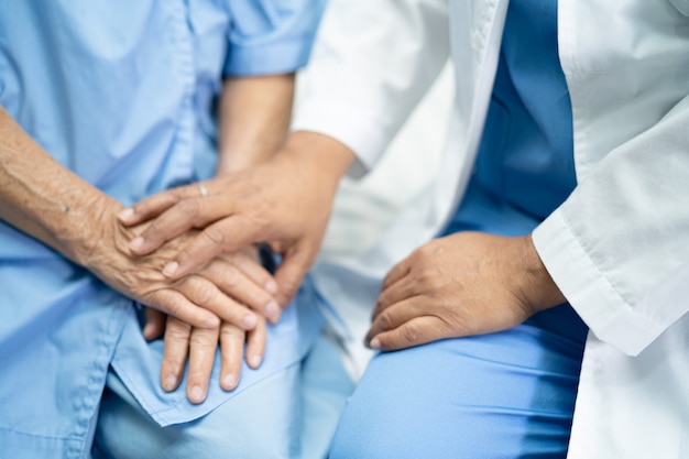 Doctor touching hands Asian senior woman patient with love.