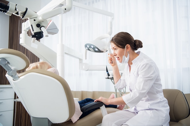 The doctor treating one's child's teeth in the dental clinic.