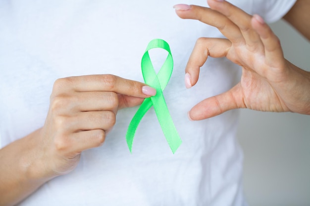 Doctor in uniform holds a green ribbon as a symbol of lyme disease