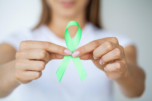 Doctor in uniform holds a green ribbon as a symbol of Lyme disease