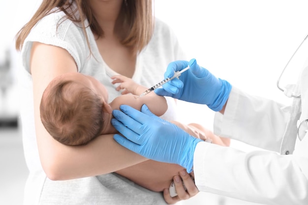 Doctor vaccinating cute baby in hospital