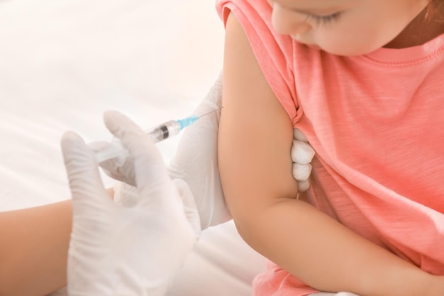 Doctor vaccinating little child in clinic