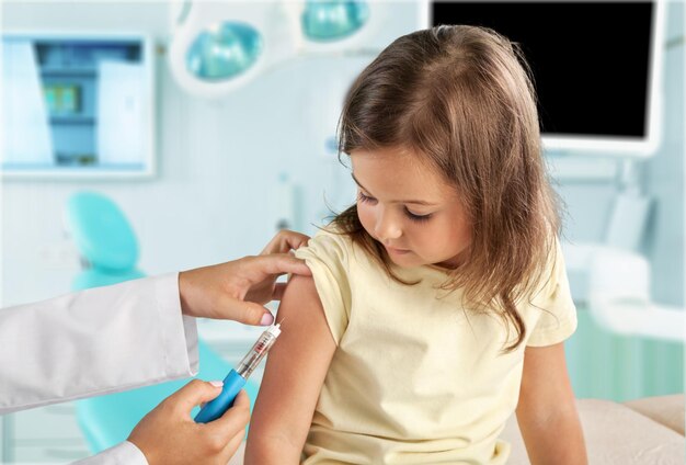 Doctor vaccinating little girl isolated on a white background