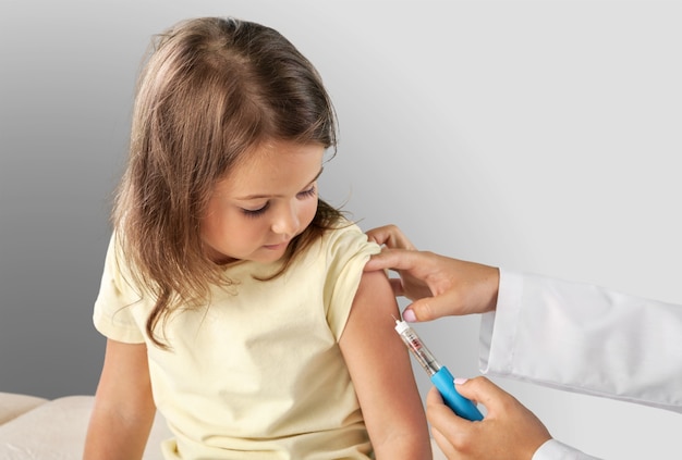 Doctor vaccinating little girl isolated on a white background