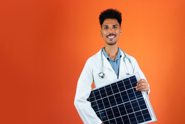 Doctor or Veterinarian Isolated on Orange Background Black Medical Resident Holding Solar Panel