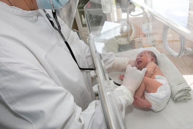 A doctor watches over a premature baby in the hospital