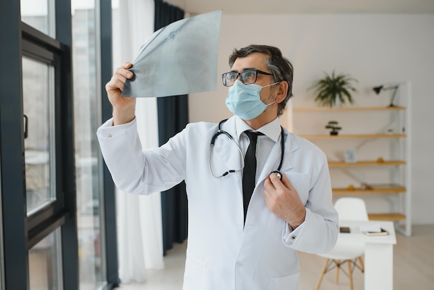 Doctor wearing mask and looking at chest xray