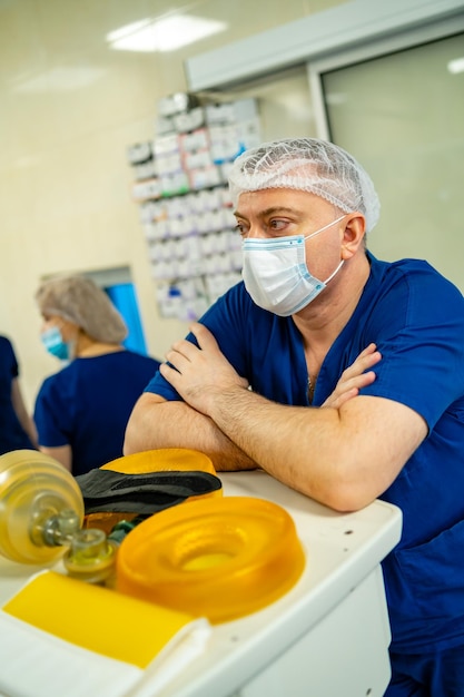 Doctor wearing mask and scrubs Medician near professional equipment for lungs ventillation