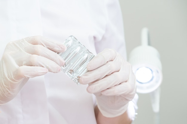 Doctor wearing medical gloves holding a pack of rectal or vaginal suppositories