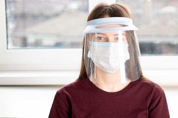 A doctor wearing a surgical face mask PPE and visor health and medicine