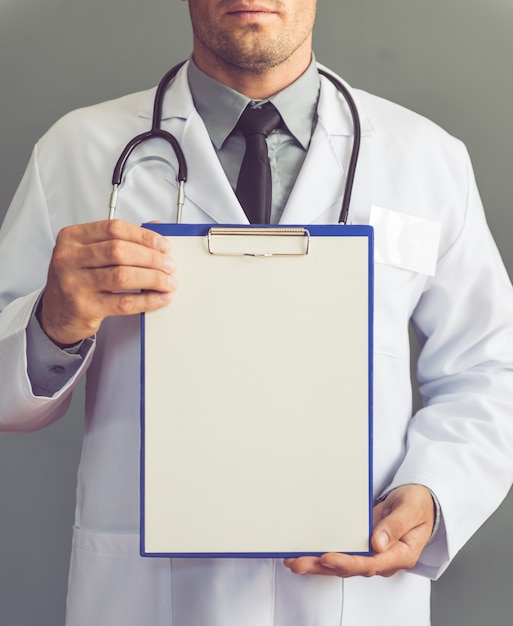 Doctor in white coat holding a blank folder