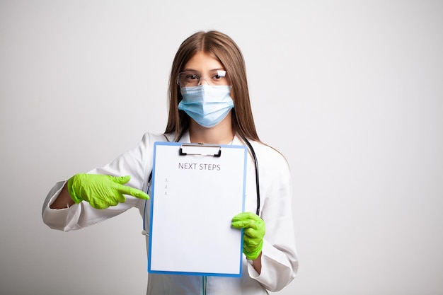 Doctor in a white coat holds a letter with text next steps