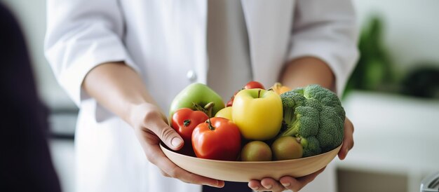 Doctor in a white coat and stethoscope on his neck is holding a fresh yellow pepper in his hands