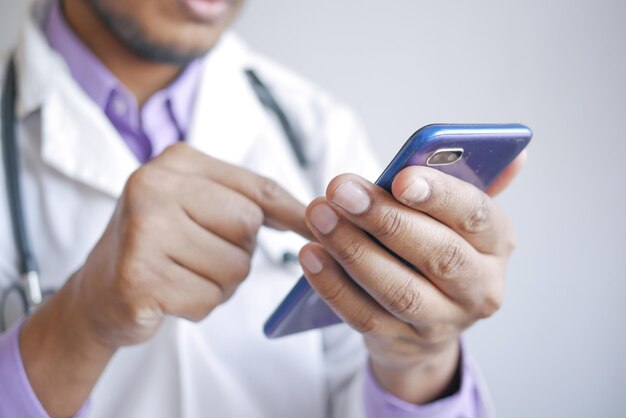 Doctor in white coat using a smartphone