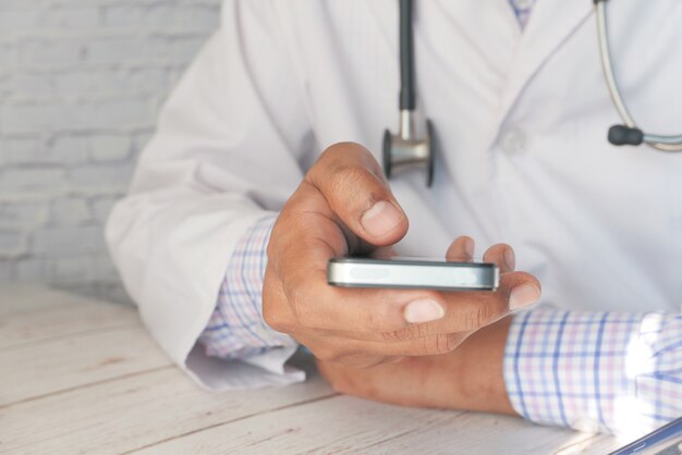 doctor in white coat using a smartphone.