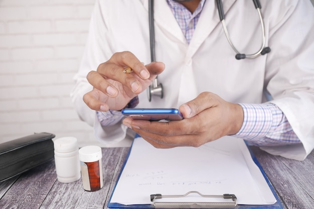 Doctor in white coat using a smartphone