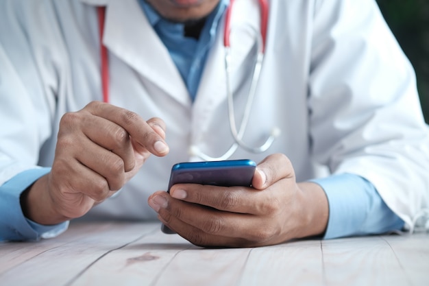 Doctor in white coat using a smartphone