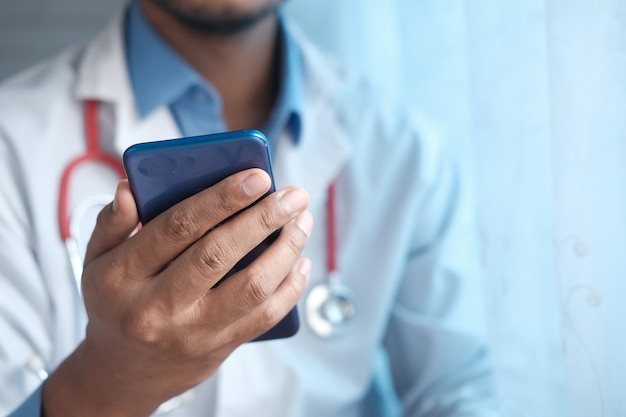 Doctor in white coat using a smartphone