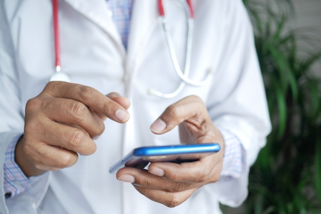 Doctor in white coat using a smartphone