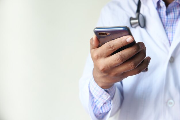 doctor in white coat using a smartphone.