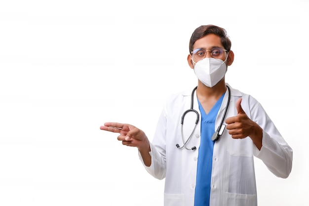 Doctor in a white coat with a stethoscope and showing thumbs up over white background.