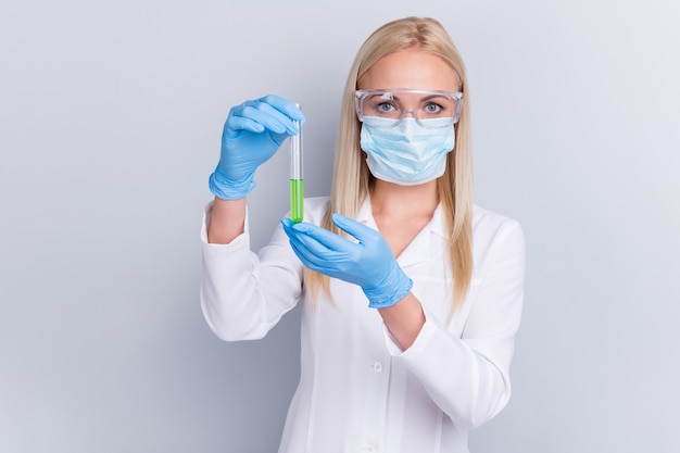 doctor in white suit holding pipettes with liquid