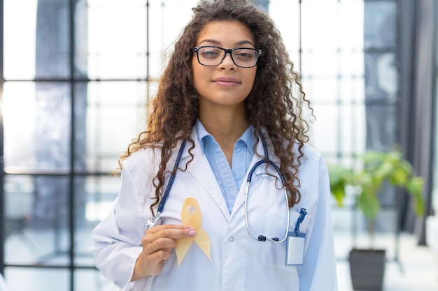 Doctor with golden ribbon Childhood cancer awareness concept