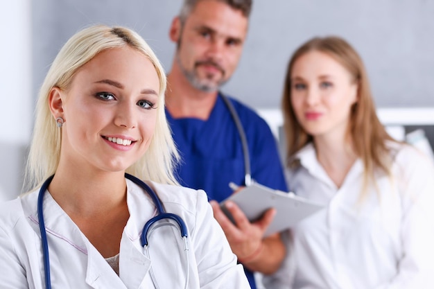 Photo a doctor with a stethoscope on his neck and a female doctor in the background