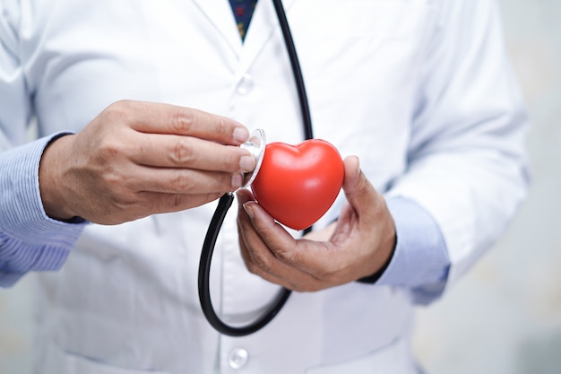 Doctor with stethoscope holding red heart in his hand