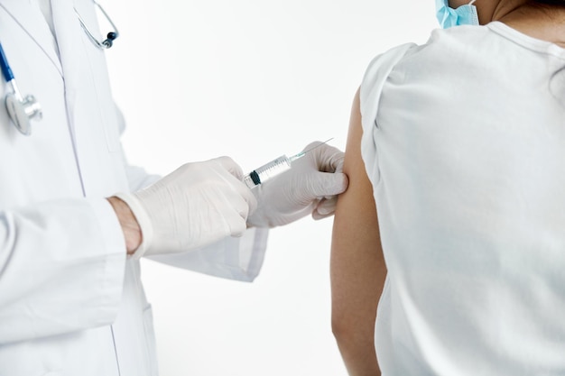 Doctor with a syringe in hand injecting a vaccine in protective gloves in a hospital covid