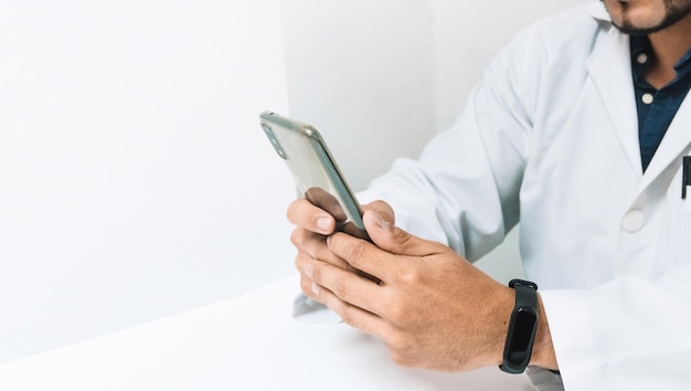 Doctor with white uniusing his phone