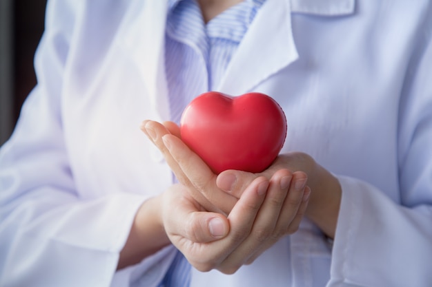 Photo doctor woman hand holding the red heart with carefully