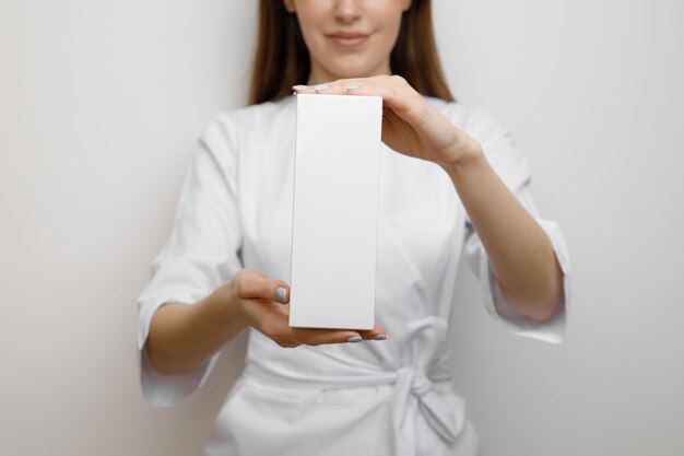 Doctor woman holding up small box