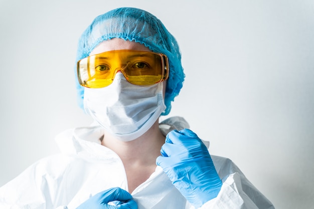 Doctor woman puts on face mask and looks at camera. Cold, flu, virus, tonsillitis, acute respiratory disease, quarantine, epidemic concept.