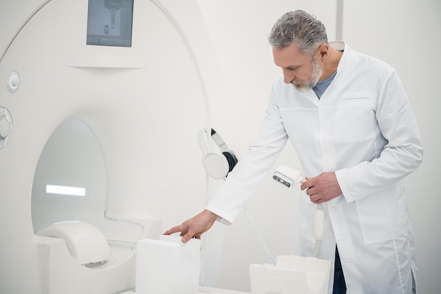 Doctor at work Doctor in a lab coat standing near MRI scanner