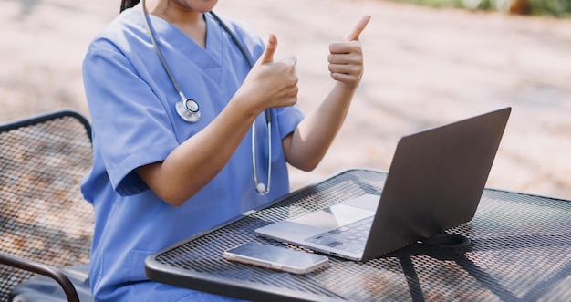 Doctor working with laptop computer and writing on paperwork Hospital background