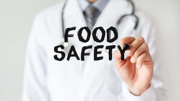 Doctor writing word Food Safety with marker