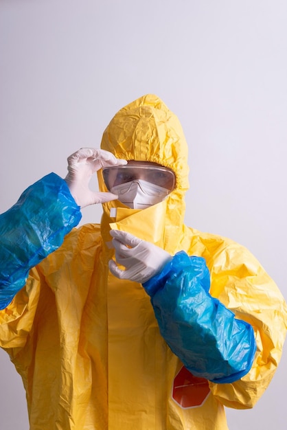 Doctor in a yellow antiplague suit from covid on a gray background