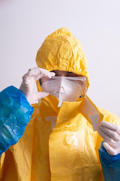 Doctor in a yellow antiplague suit from covid on a gray background