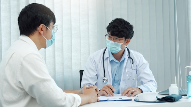 Doctors are explaining the treatment of a patients illness while wearing a mask during the epidemic