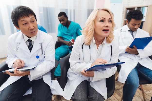 Doctors are sitting at a doctoral conference.