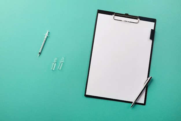 Photo doctors desk with tablet, pen, syringe and ampoules