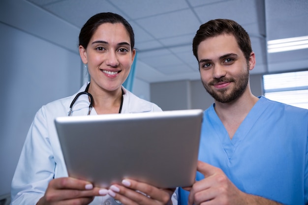 Doctors discussing over digital tablet in hospital