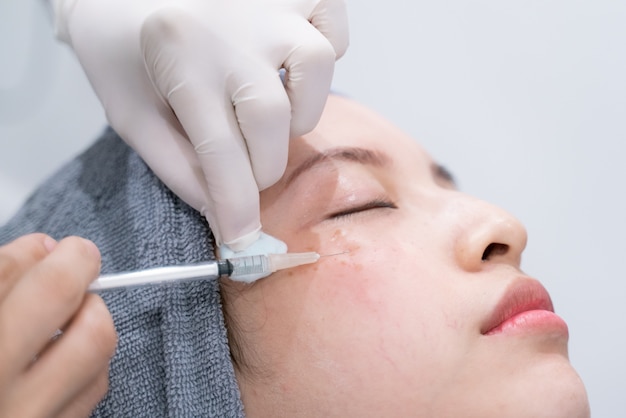 Doctors hands making an injection cosmetic in young woman face. Beauty Treatment.