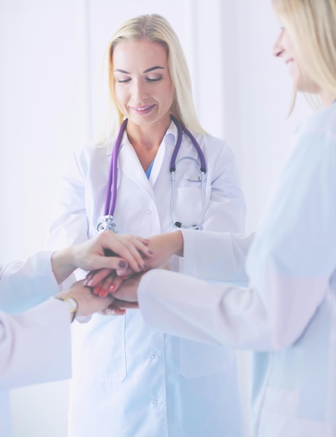 Doctors and nurses in a medical team stacking hands