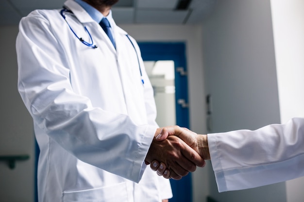 Doctors shaking hands in corridor