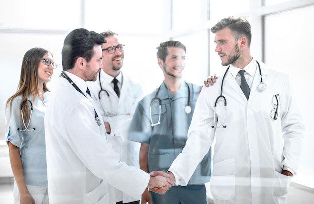 Doctors shaking hands in hospital corridor