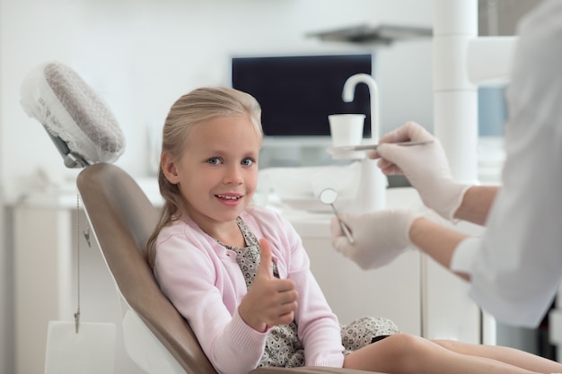 At the doctors. Small blonde girl being examoined by the pediodontist