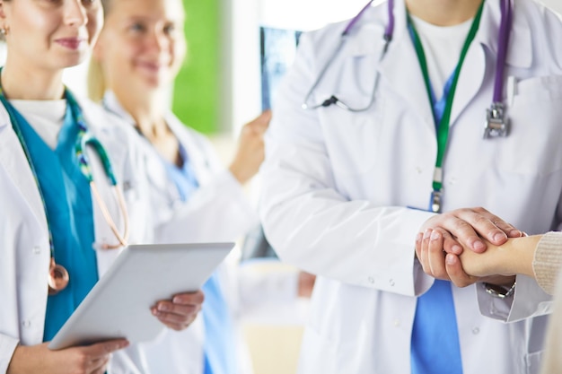 Doctors using a tablet in hospital standing in office