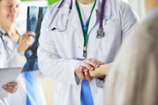 Doctors using a tablet in hospital standing in office